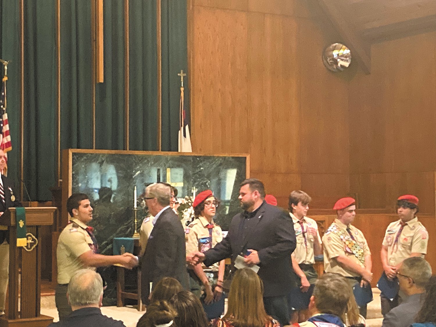 GREAT ACHIEVEMENT: Ken Hopkins and Council President Chris Paplauskas shake hands with each of the Eagle scouts. (Herald photo)